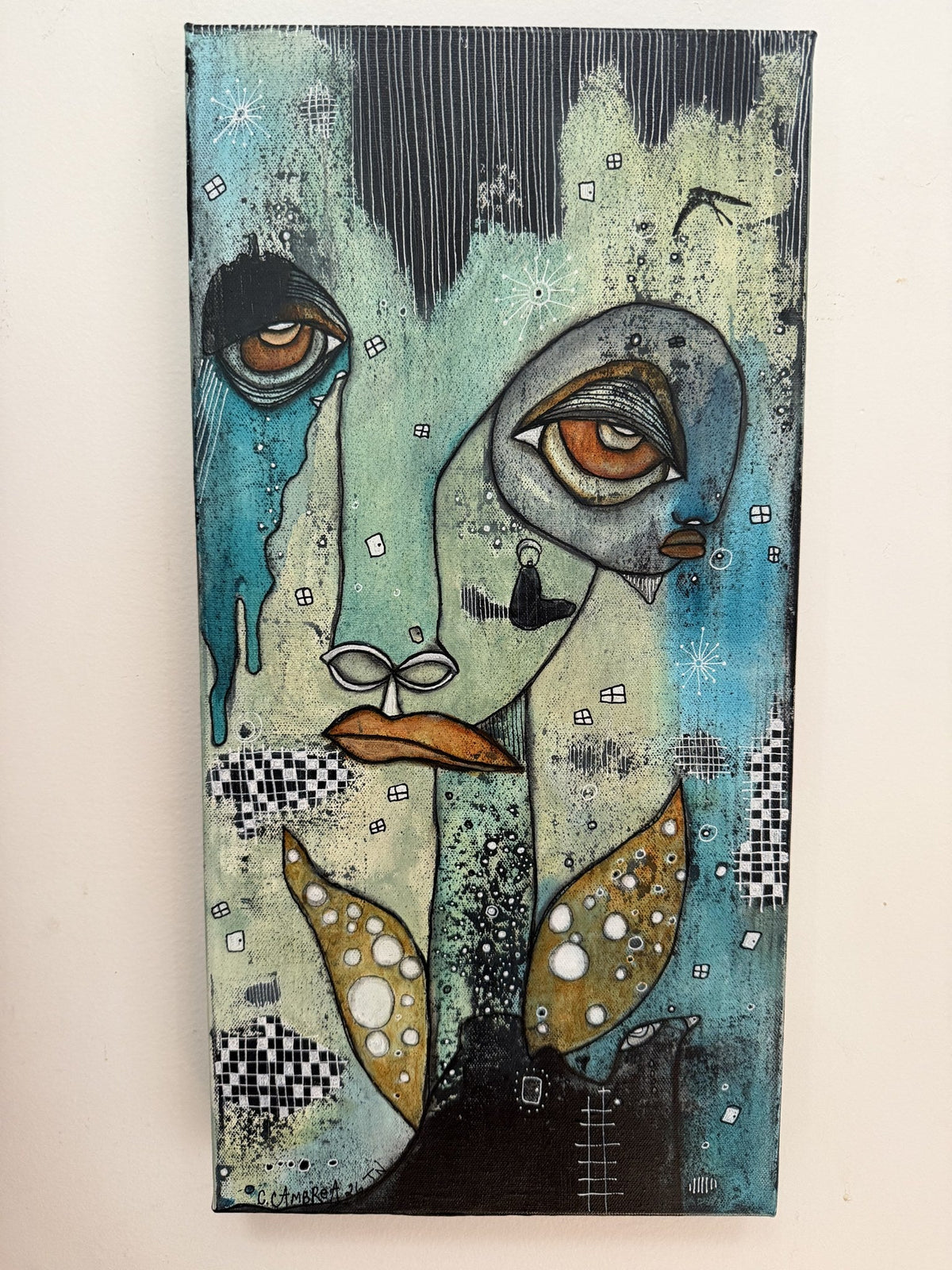 Mixed media portrait painting on canvas featuring two overlapping teal and gold faces with wing-like shapes