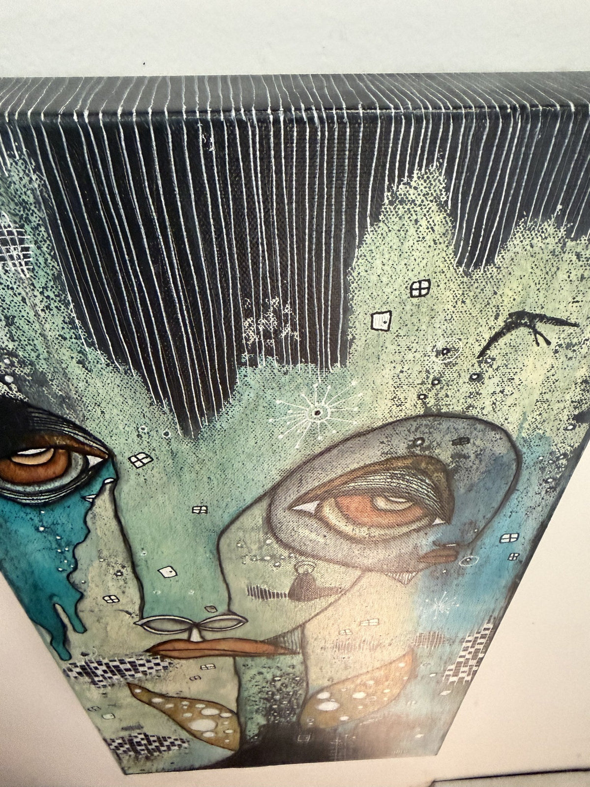 Angled overhead view of canvas showing painted top edge, striped dark sky, and both faces below