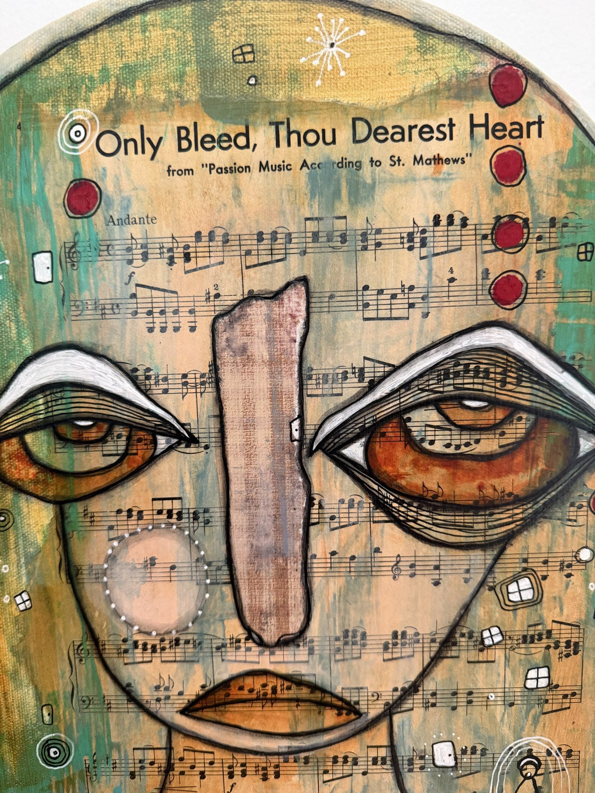 Detail of the painted face's eyes and forehead with sheet music title text and red circles.