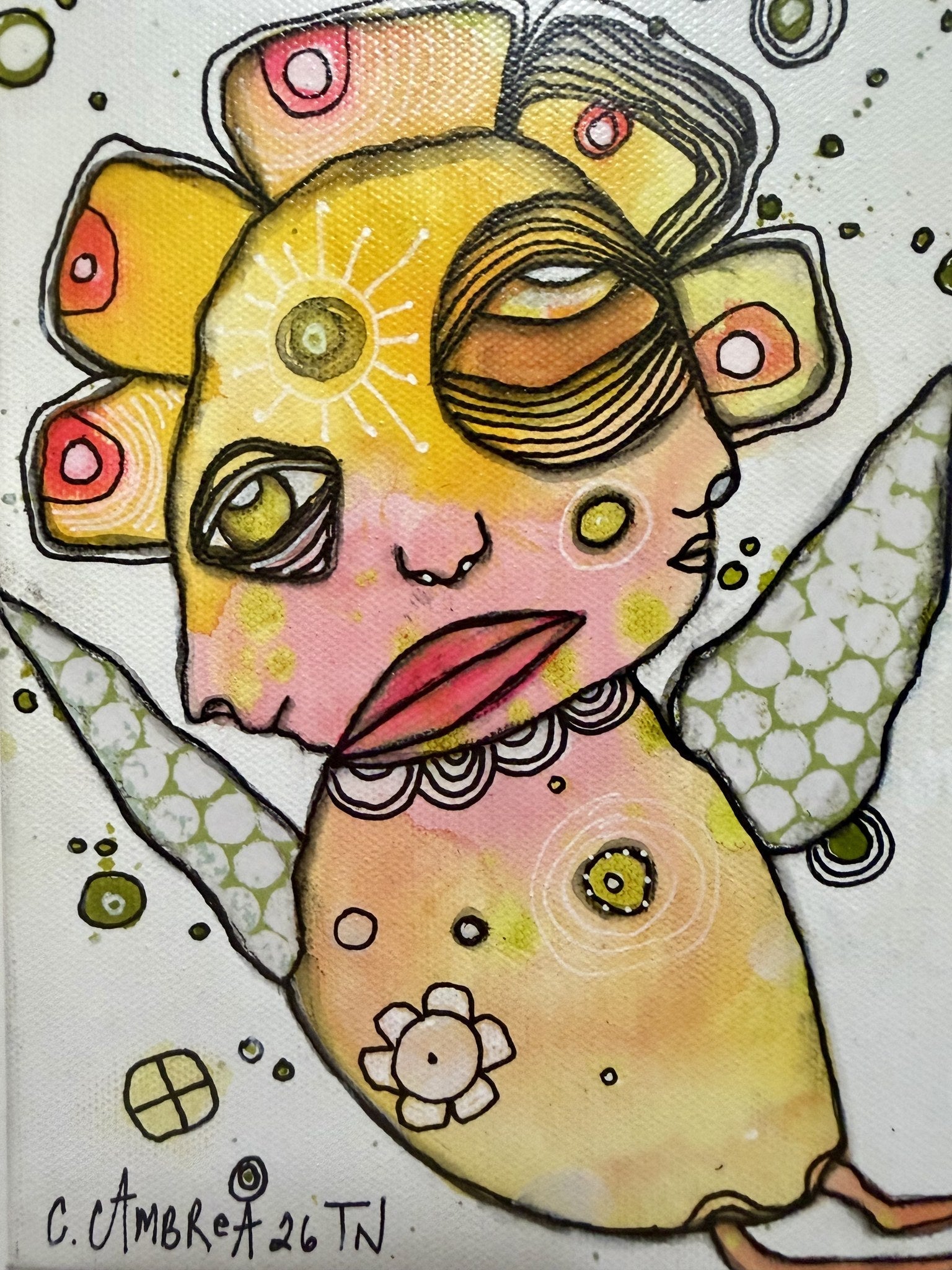 Close-up detail of the painted face showing layered patterns, a sun motif, and one eye peeking through