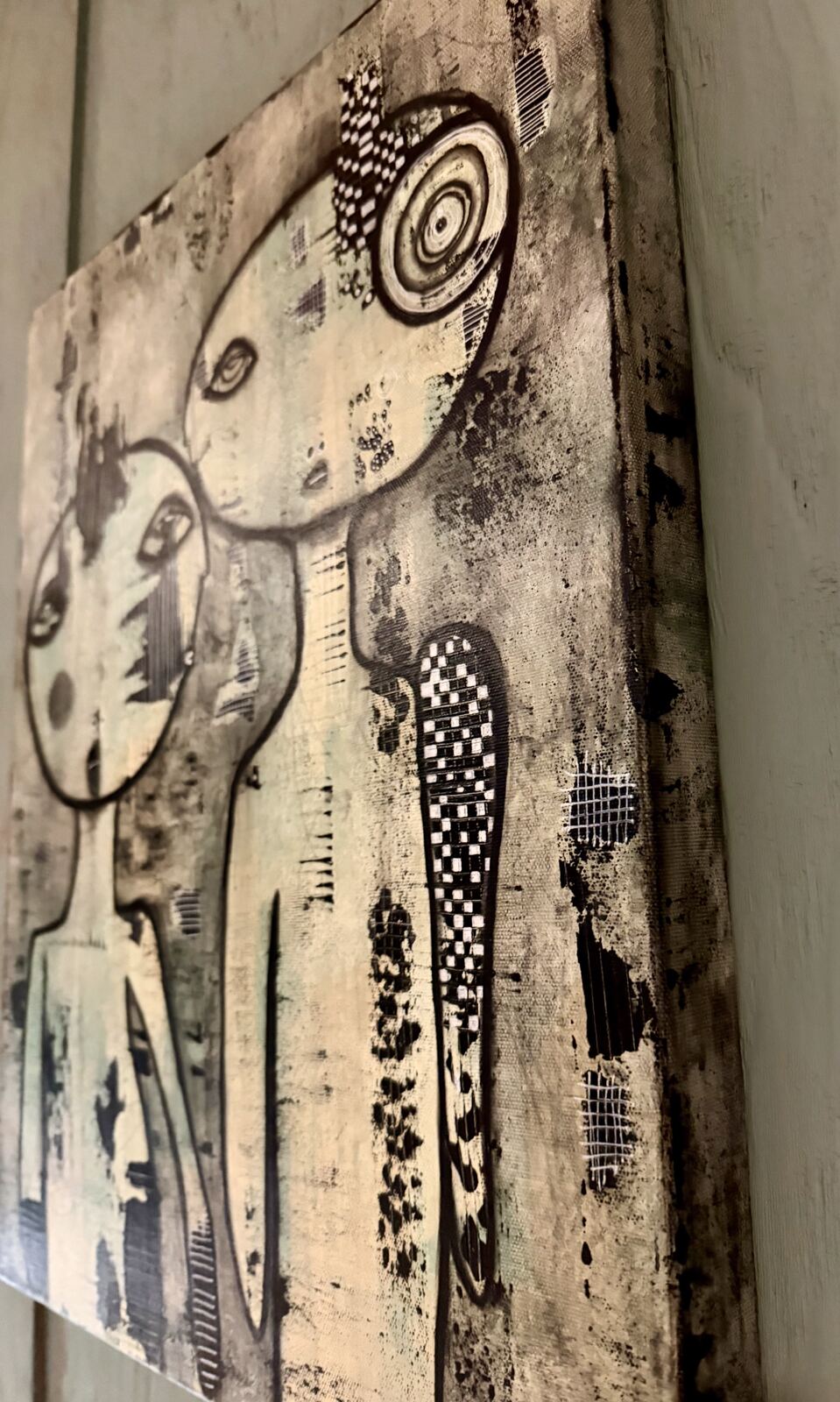 Angled view of "We Meet Again" showing the canvas edge and spiral eye detail